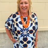 Printed short sleeve top in light blue with colorful indigo, orange, and yellow pattern, featuring a boat neck and relaxed A-line shape