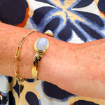 Gold cuff bracelet with an oval blue lace agate stone at the center, offering soft blue tones and a serene, elegant feel.