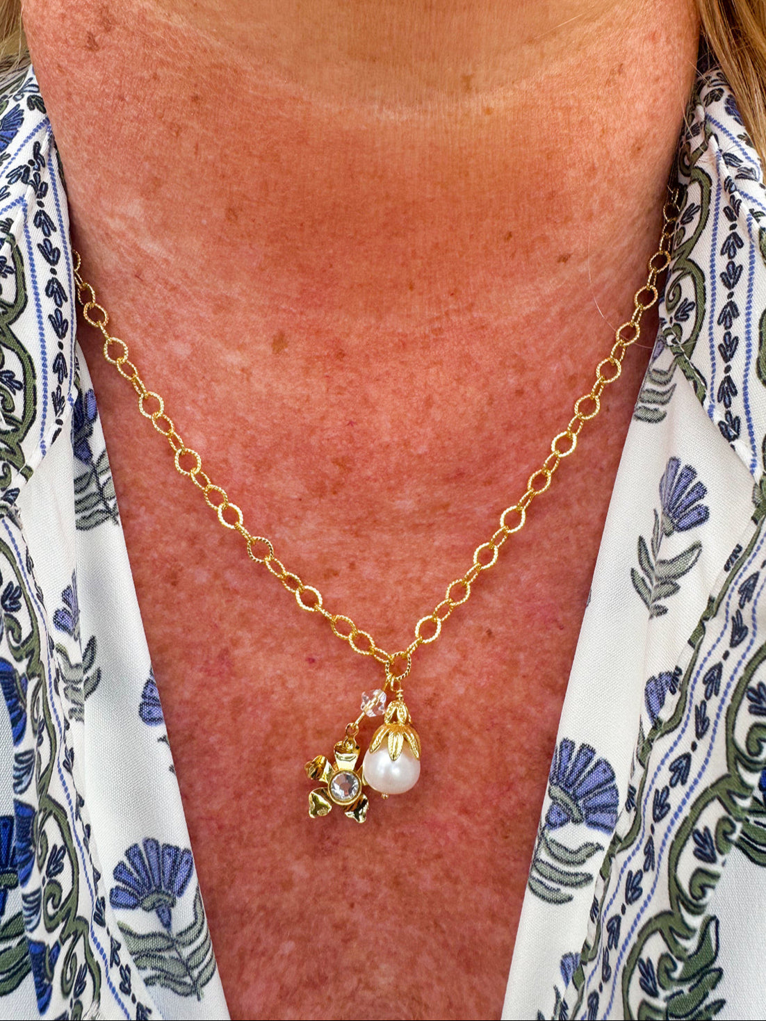Bright gold-tone small chain link necklace with gold flower crystal pendant and modern pearl pendant.