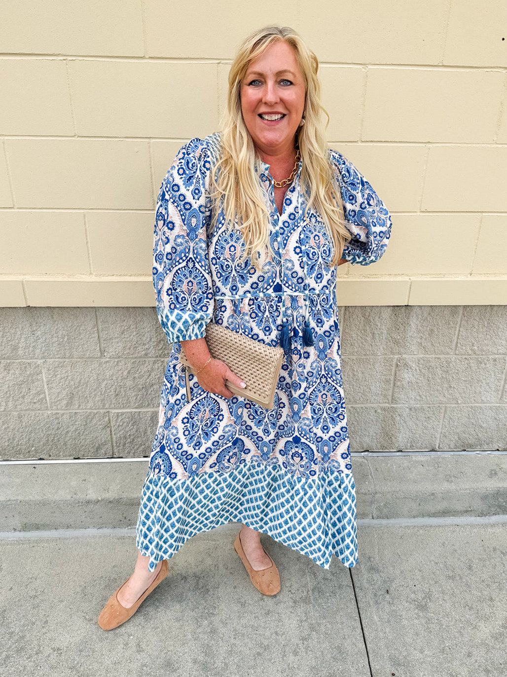 Blue and light orange paisley midi dress with cream accents, tie-neck with tassels, and ¾-length cuffed sleeves