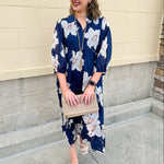 Navy midi dress with white floral details, collar, and 3/4-length sleeves