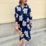 Navy midi dress with white floral details, collar, and 3/4-length sleeves