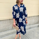 Navy midi dress with white floral details, collar, and 3/4-length sleeves