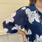 Navy midi dress with white floral details, collar, and 3/4-length sleeves
