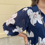 Navy midi dress with white floral details, collar, and 3/4-length sleeves