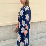 Navy midi dress with white floral details, collar, and 3/4-length sleeves
