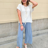 Linen-cotton blend short-sleeve top with front tie and raw hem in a soft neutral oatmeal shade.