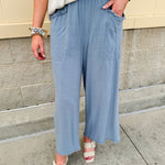 Light blue striped linen blend wide-leg pants with elastic waist, front pockets, and frayed details for an easy, relaxed fit.