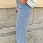 Light blue striped linen blend wide-leg pants with elastic waist, front pockets, and frayed details for an easy, relaxed fit.