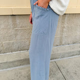 Light blue striped linen blend wide-leg pants with elastic waist, front pockets, and frayed details for an easy, relaxed fit.