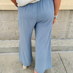 Light blue striped linen blend wide-leg pants with elastic waist, front pockets, and frayed details for an easy, relaxed fit.
