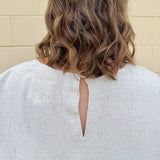Linen-cotton blend short-sleeve top with front tie and raw hem in a soft neutral oatmeal shade.