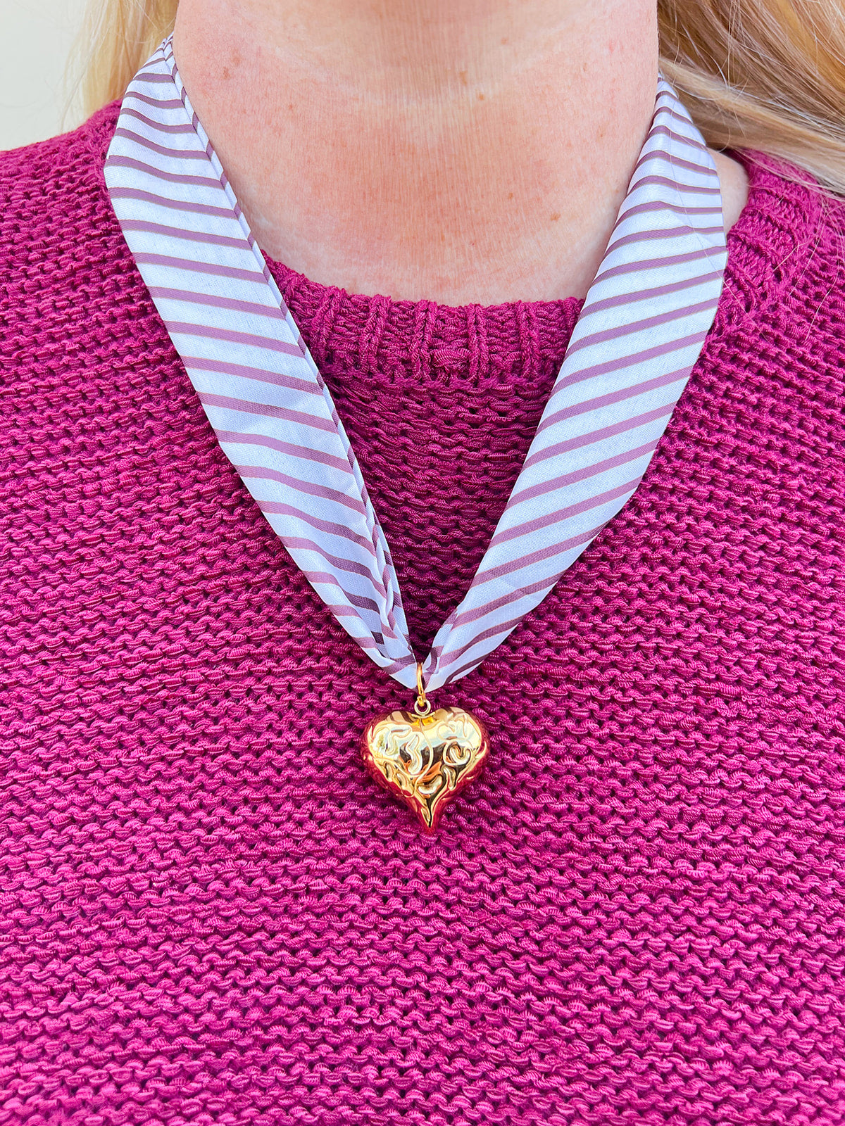 Garnet and cream scarf-style necklace with a gold heart charm, styled for fall, holiday, or gameday looks.