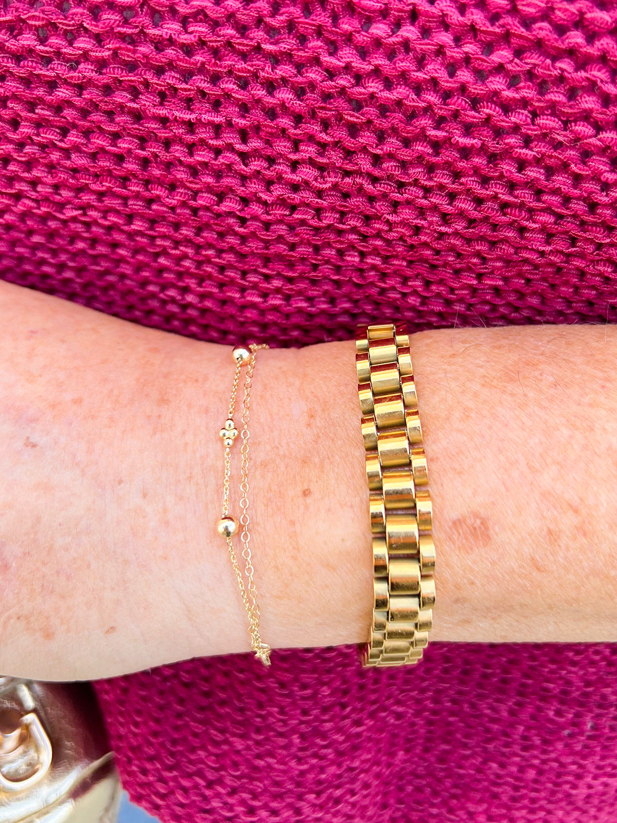 Gold watch band bracelet with clip clasp on neutral background