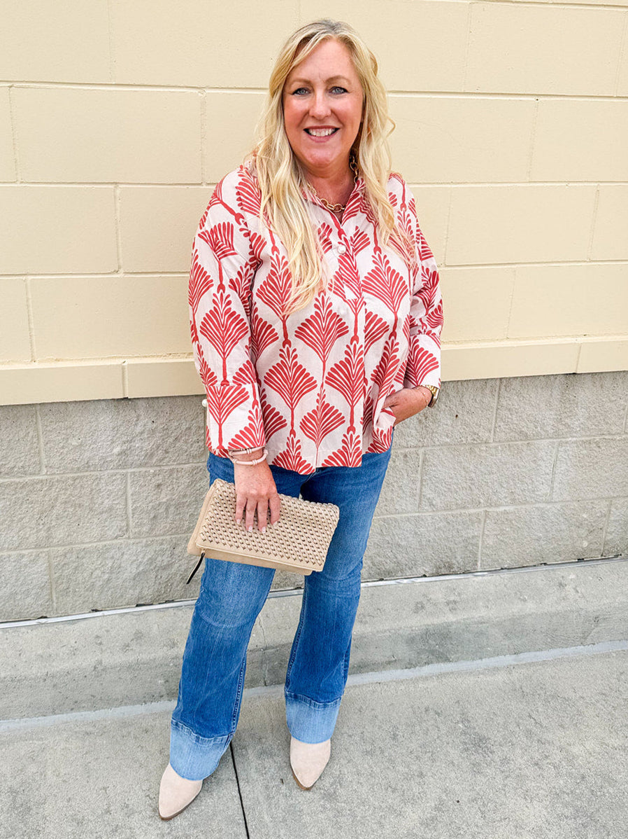 Cream shirt with rust pattern, collar, one button, and ¾-length cuffed sleeves