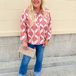 Cream shirt with rust pattern, collar, one button, and ¾-length cuffed sleeves