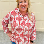 Cream shirt with rust pattern, collar, one button, and ¾-length cuffed sleeves