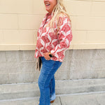 Cream shirt with rust pattern, collar, one button, and ¾-length cuffed sleeves