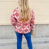 Cream shirt with rust pattern, collar, one button, and ¾-length cuffed sleeves