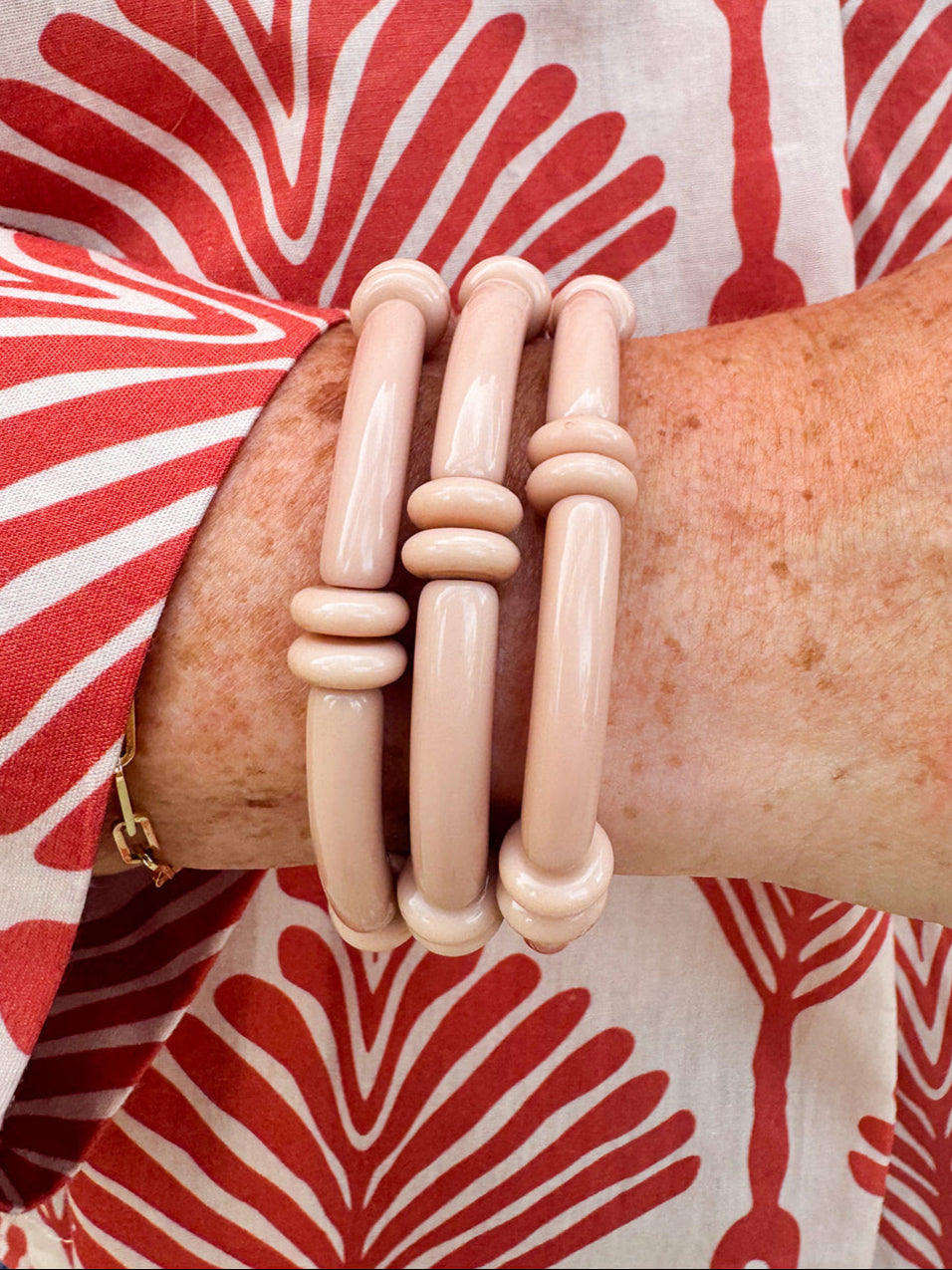 Minimalist skinny tube bracelet with metal bead accents, styled in a layered stack on a neutral-toned wrist display