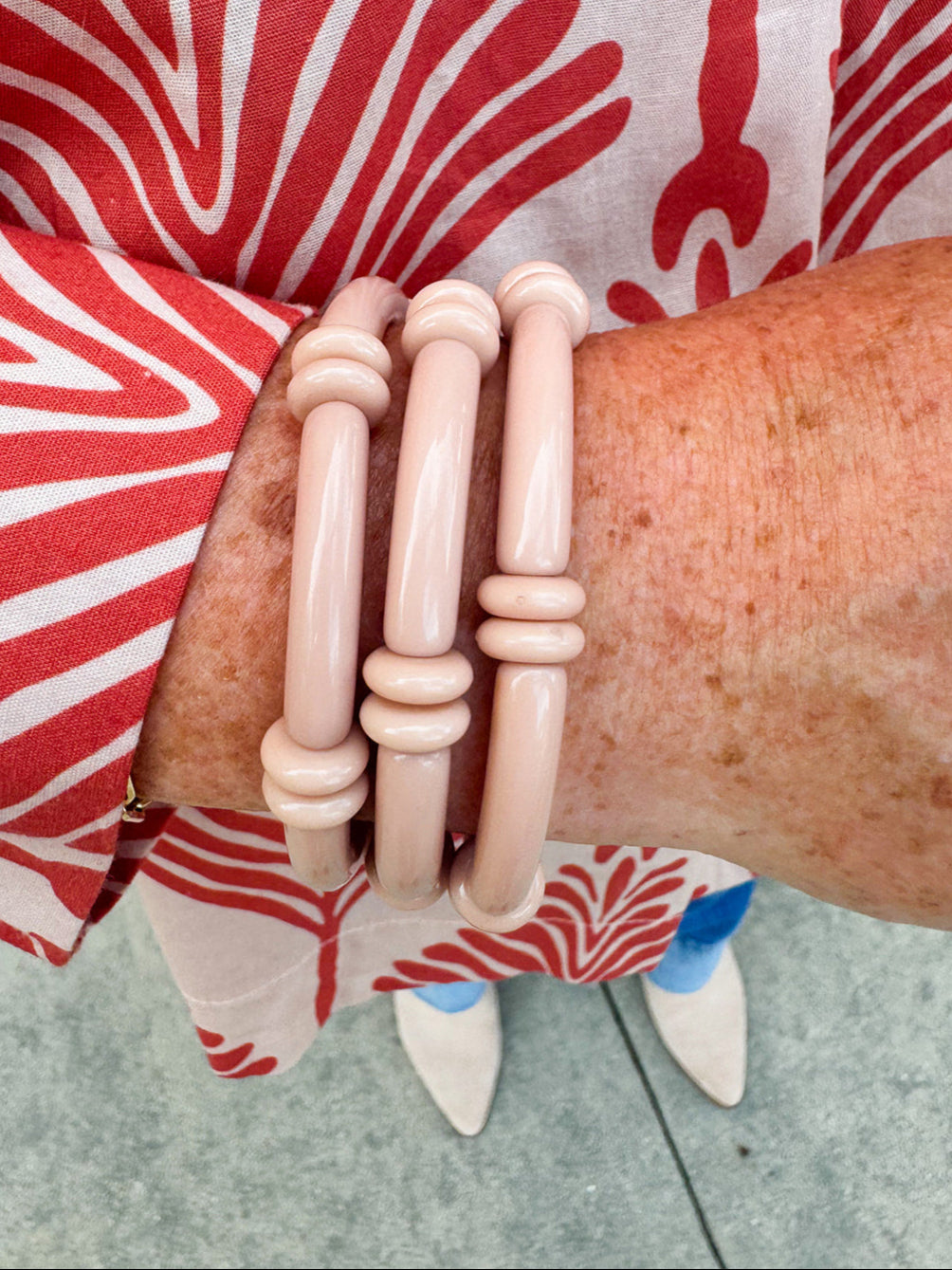 Minimalist skinny tube bracelet with metal bead accents, styled in a layered stack on a neutral-toned wrist display