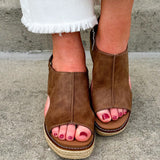 Chocolate brown vegan leather wedge with strap-back peep toe, open side slits, and raffia wedge bottom