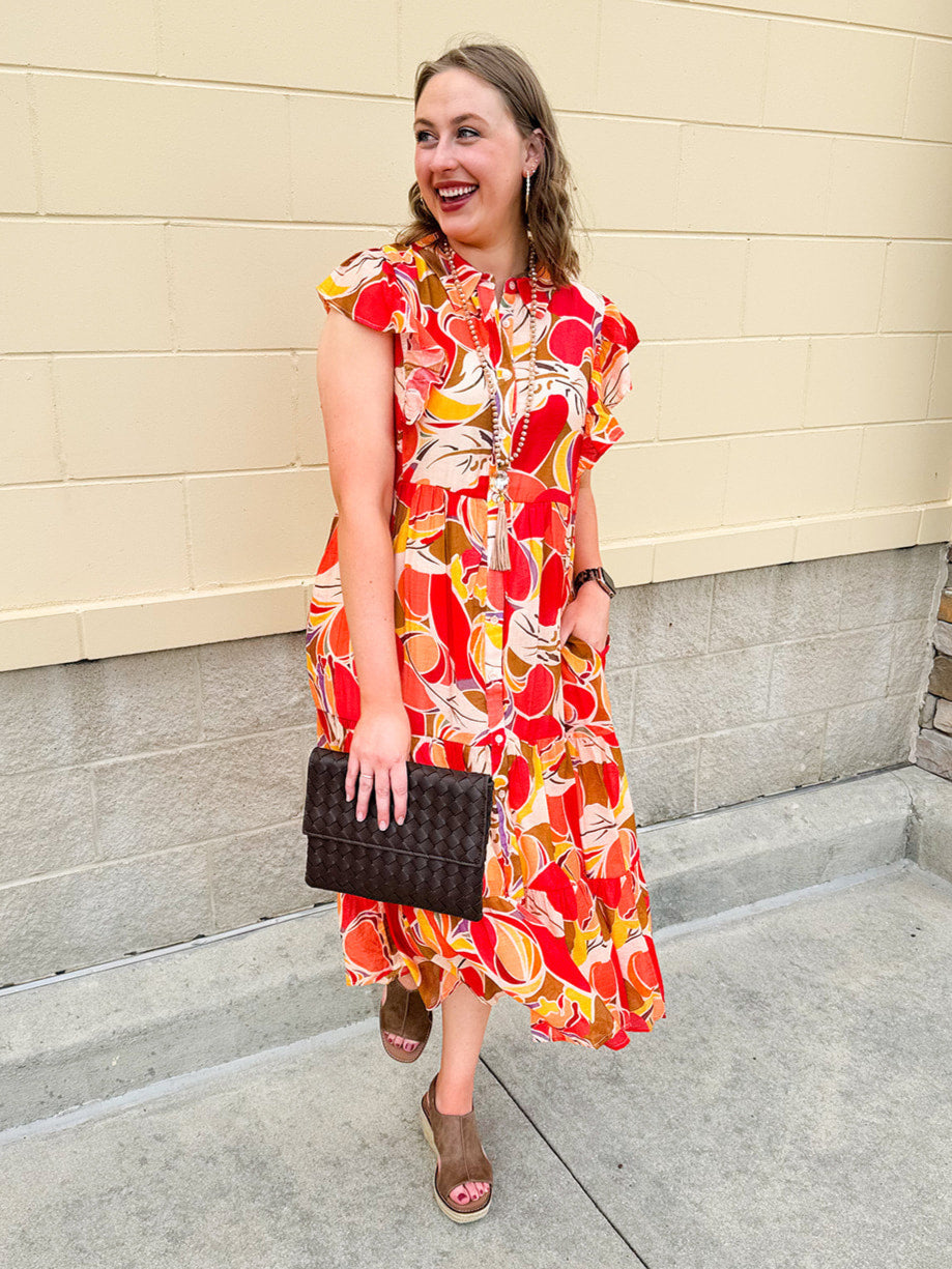 Collared midi dress with red, cream, and green pattern, ruffle sleeves, and buttons down front