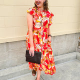 Collared midi dress with red, cream, and green pattern, ruffle sleeves, and buttons down front