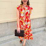Collared midi dress with red, cream, and green pattern, ruffle sleeves, and buttons down front