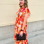 Collared midi dress with red, cream, and green pattern, ruffle sleeves, and buttons down front