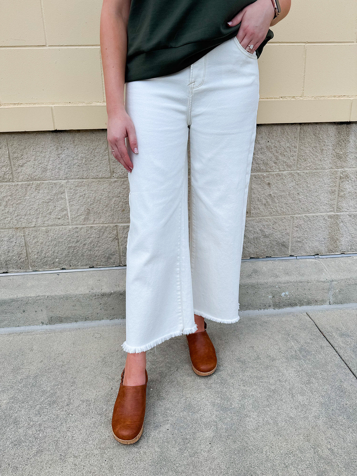 Model wearing the Risen Show Stopper Tummy Control Cream Jeans featuring a high-rise fit, frayed hem, and wide-leg silhouette – styled with a tucked-in top for a flattering, fashion-forward look.