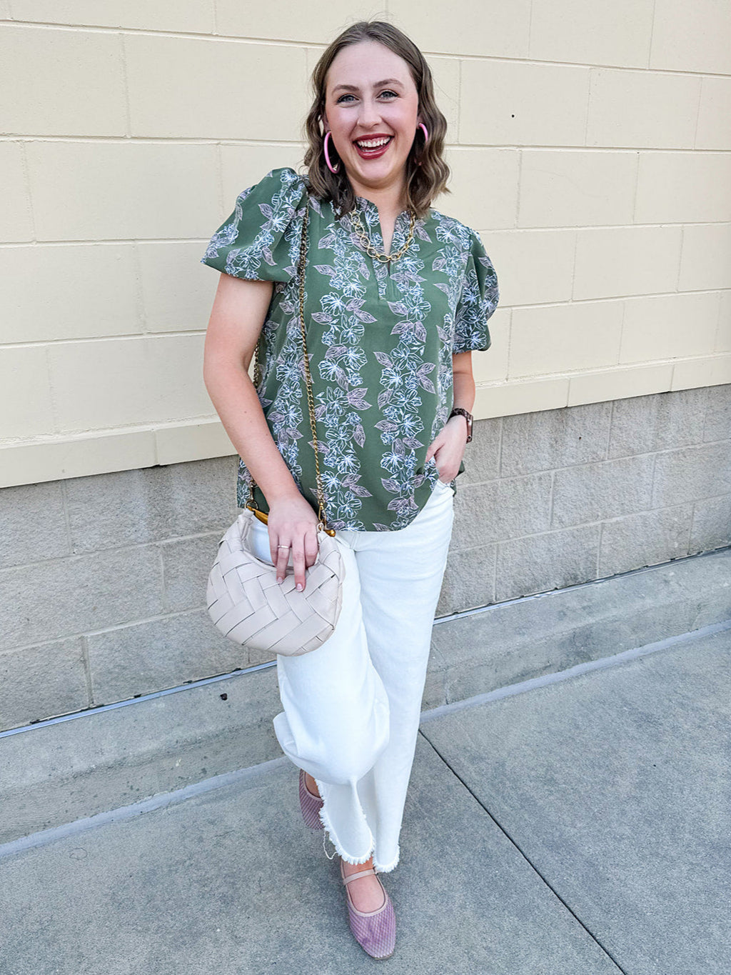 Green floral top with white and pink flowers, short sleeves, and V-neckline