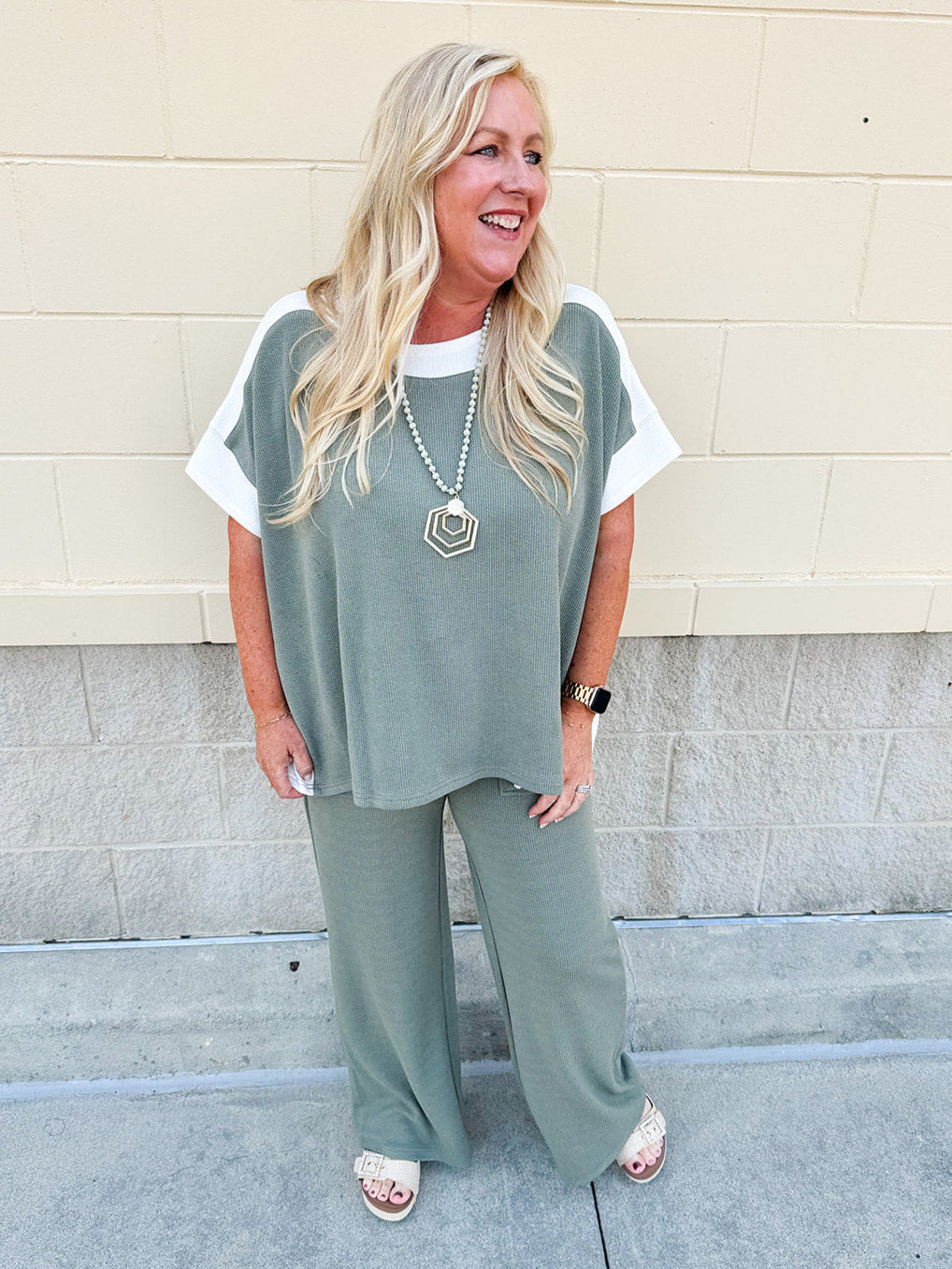 Sage green ribbed lounge pants with white waistband, drawstring, and large front patch pockets in a straight-leg fit