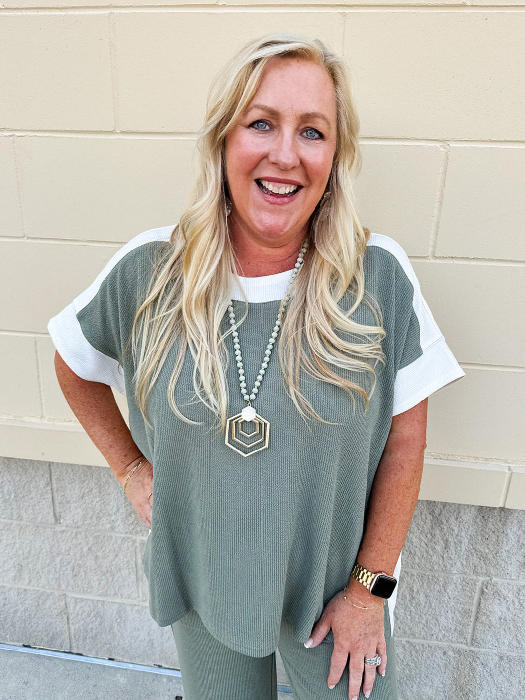 Sage green textured short sleeve top with contrast ribbed neckline and sides, styled with matching pants