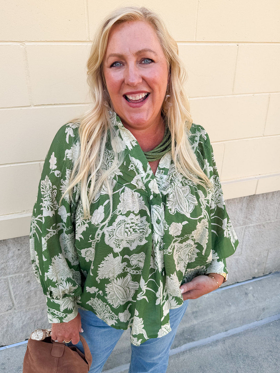 Green floral jacquard blouse with cream print, button front, pleated details, and billowy long sleeves