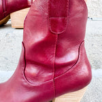 Garnet-hued western ankle boots with a pointed toe, stacked leather heel, and pull-on tabs.