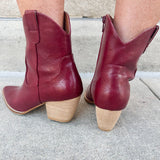 Garnet-hued western ankle boots with a pointed toe, stacked leather heel, and pull-on tabs.