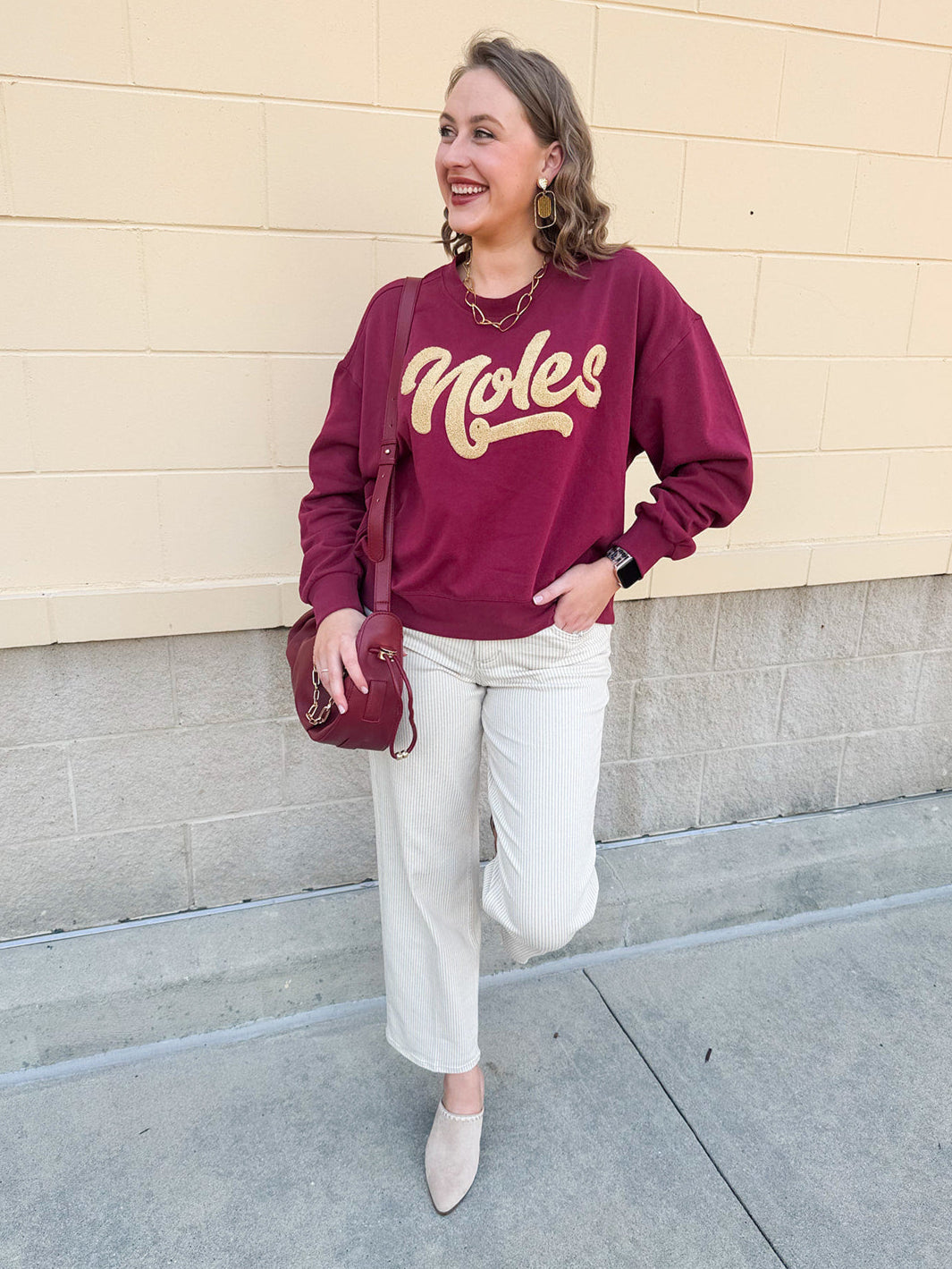 Garnet crewneck sweatshirt with dropped shoulders and gold chenille “Noles” script lettering.
