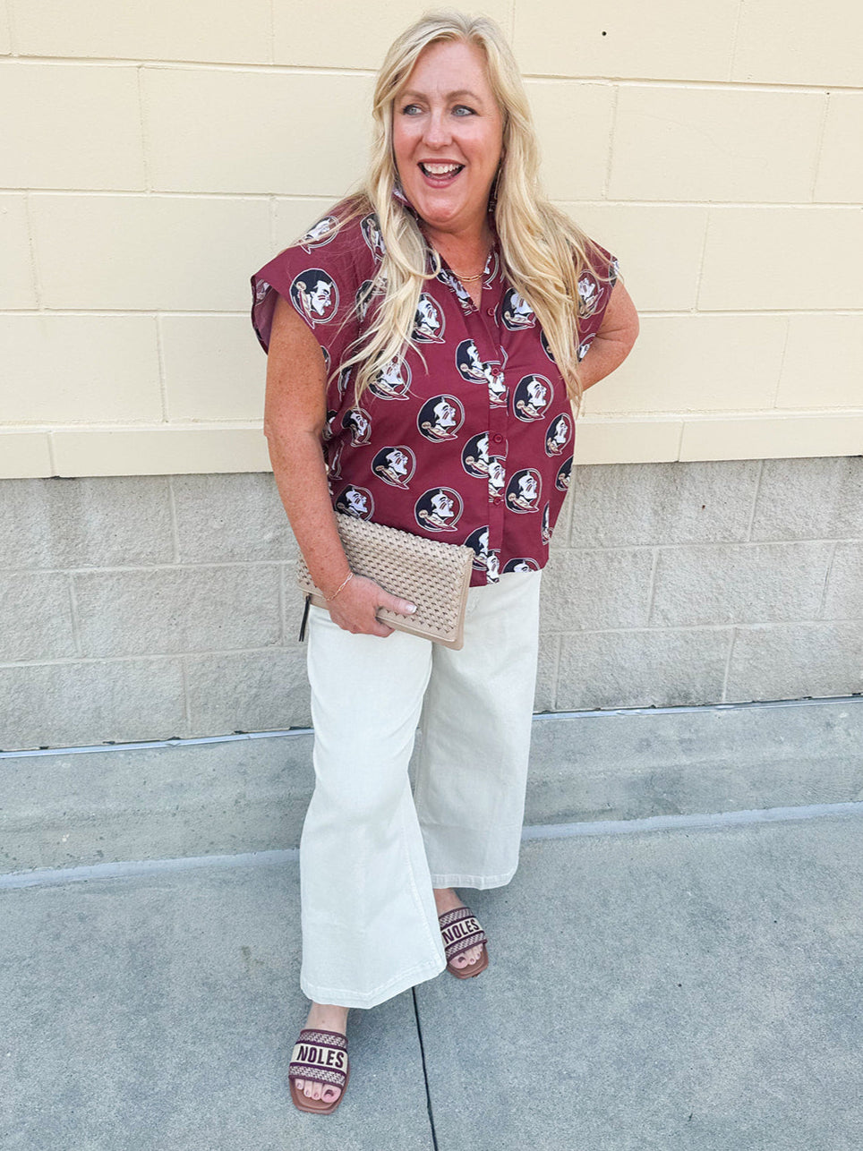 Garnet short sleeve poplin blouse with ruffle collar, button-down bodice, and gold Seminole head patterned print.