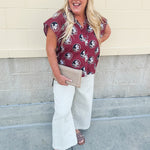 Garnet short sleeve poplin blouse with ruffle collar, button-down bodice, and gold Seminole head patterned print.