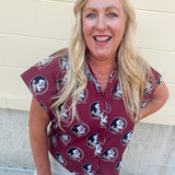 Garnet short sleeve poplin blouse with ruffle collar, button-down bodice, and gold Seminole head patterned print.