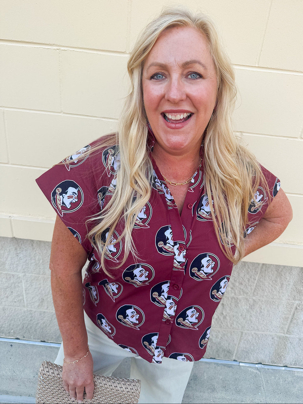 Garnet short sleeve poplin blouse with ruffle collar, button-down bodice, and gold Seminole head patterned print.