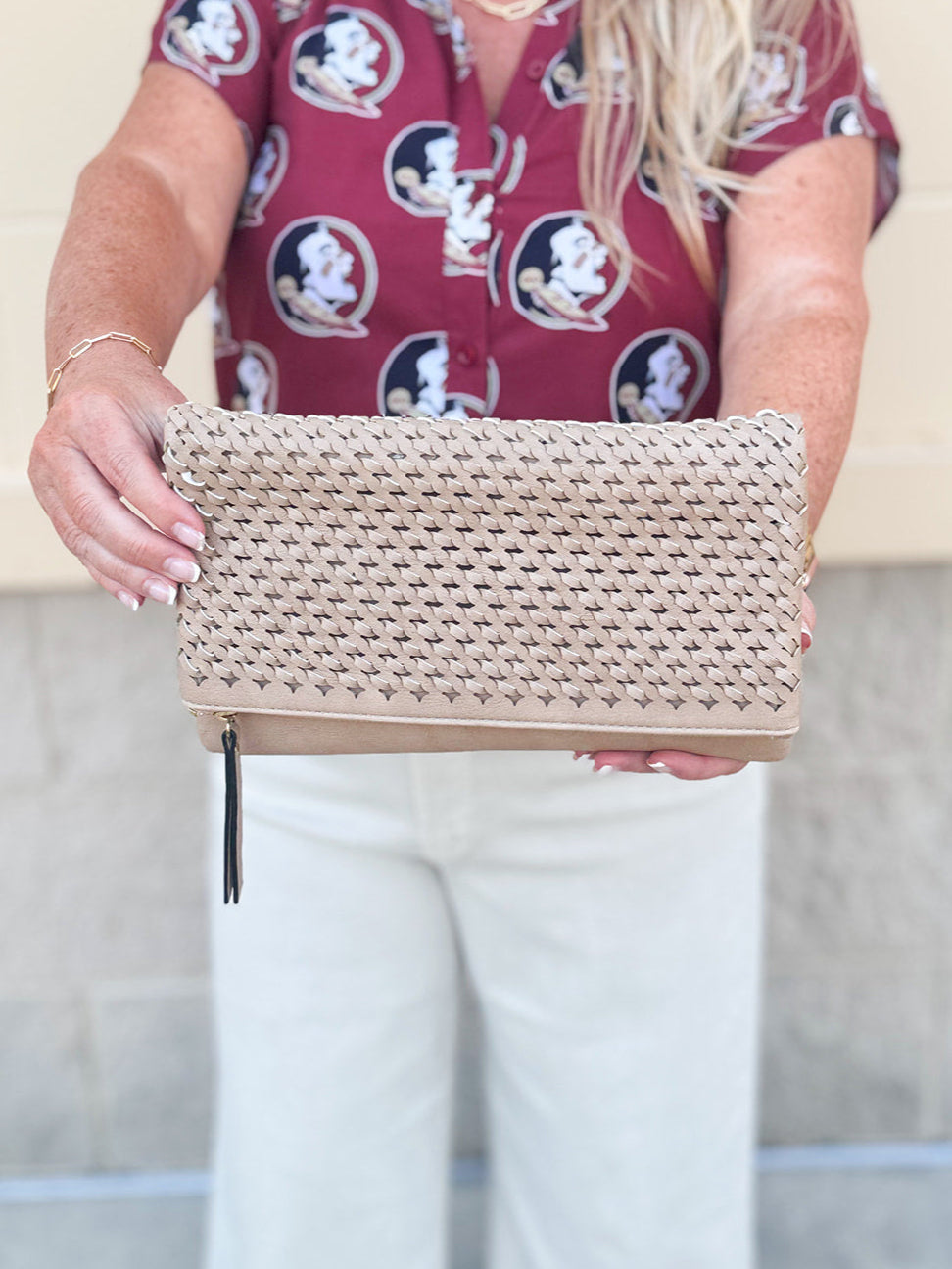 Light tan woven clutch with black and tan tassel zipper pull