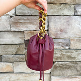 Garnet faux leather mini drawstring purse with chainlink handle woven with leather.