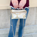 Clear stadium-approved bag with gold vegan leather accents, gold chain strap, and zipper.