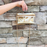 Clear stadium-approved bag with gold vegan leather accents, gold chain strap, and zipper.