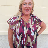 Satin blouse with ruffle collar, v-neckline, flare raglan sleeves, and abstract garnet, gold, black, and white print.