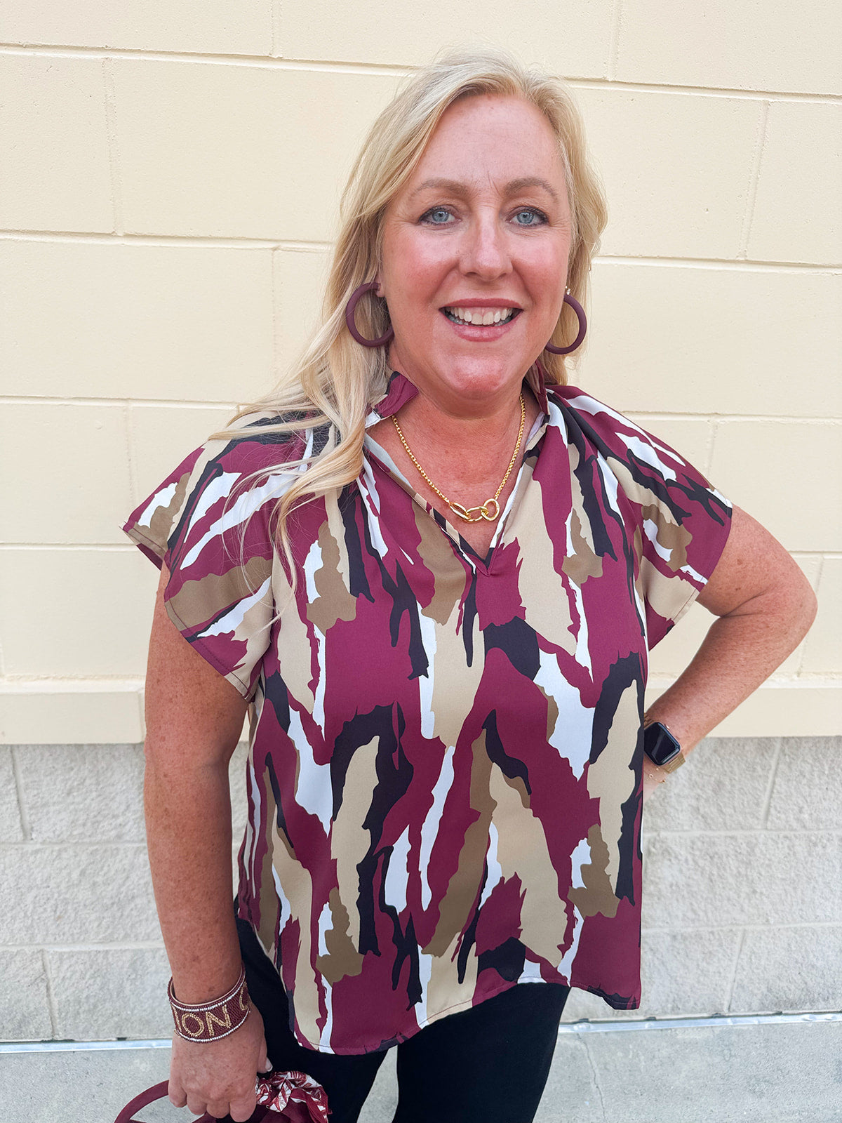 Satin blouse with ruffle collar, v-neckline, flare raglan sleeves, and abstract garnet, gold, black, and white print.