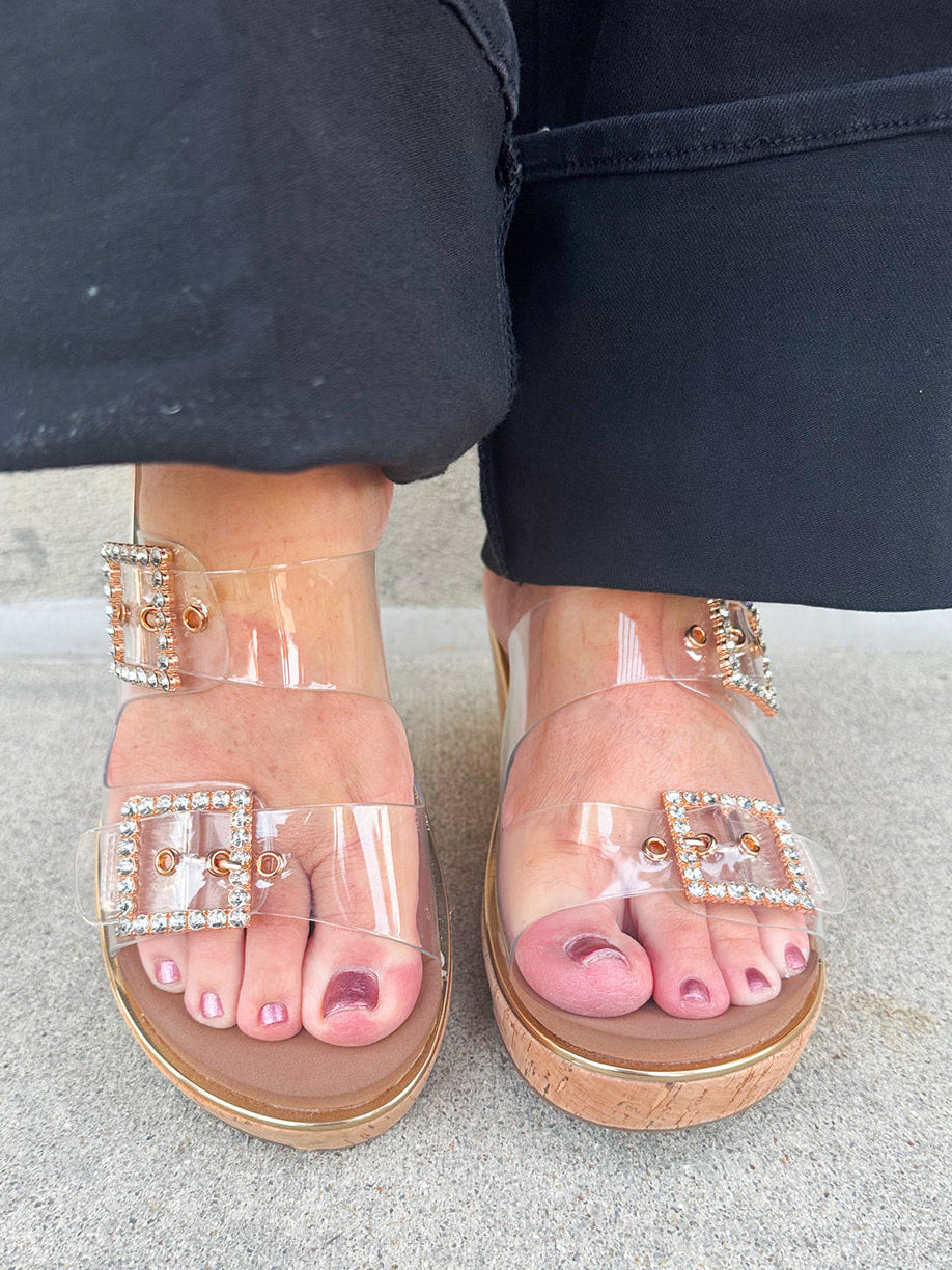  Clear rhinestone buckle wedge sandals with a neutral sole, offering stylish sparkle and all-day comfort.