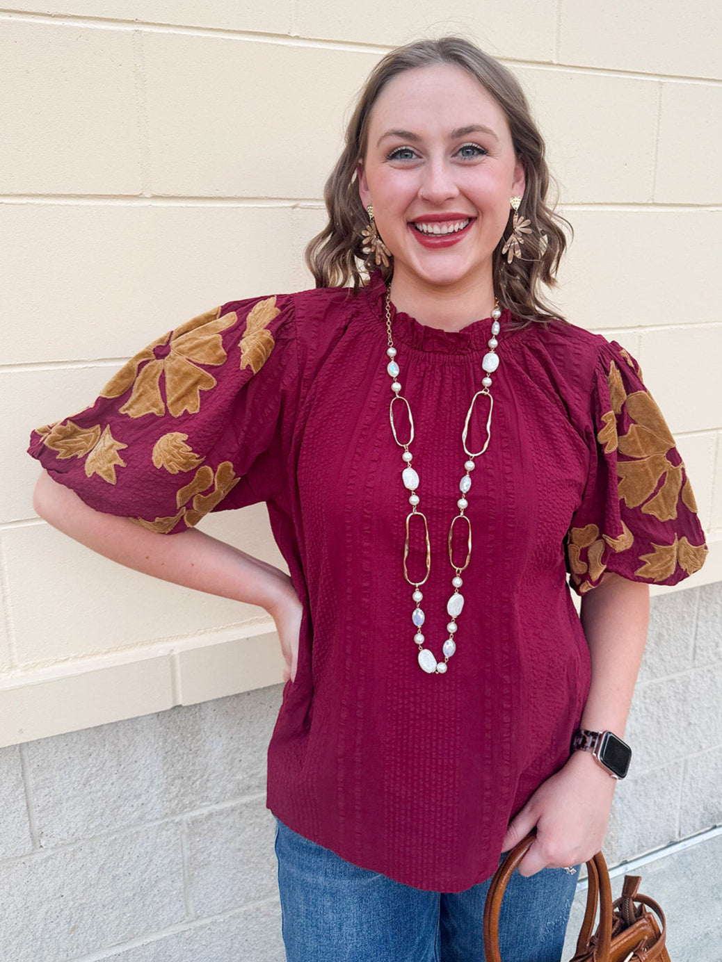Garnet short sleeve blouse with ruffle neckline and puff sleeves featuring gold/caramel velvet floral appliqué.